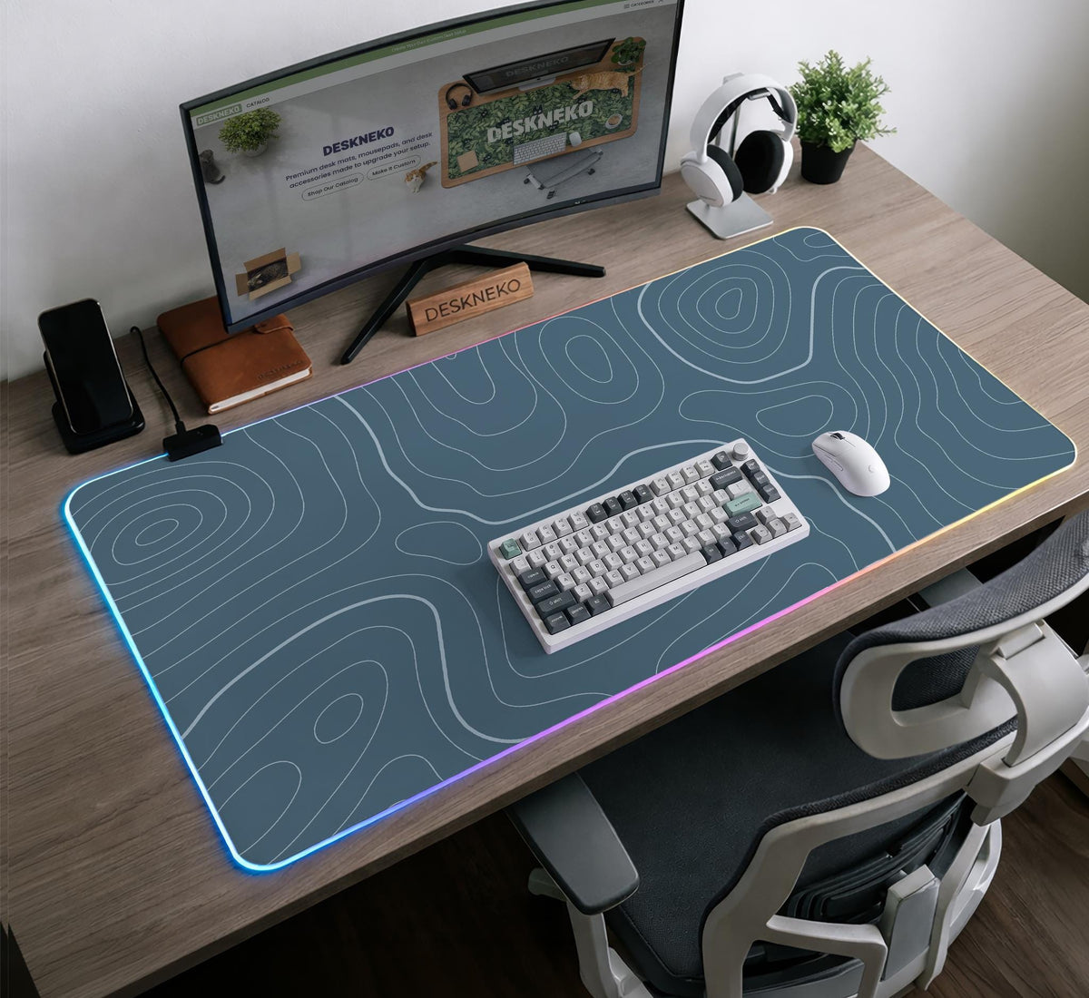A slate blue desk mat with thin contour line map art on a light background.