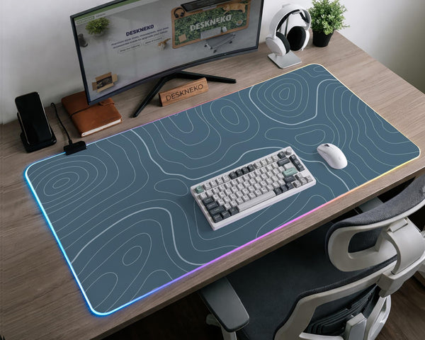Blue mousepad with a topographic line pattern on a slate background.
