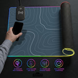 A slate blue desk mat with thin contour line map art on a light background.