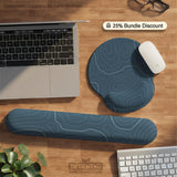 A slate blue desk mat with thin contour line map art on a light background.