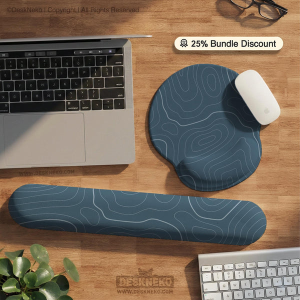 Muted blue desk mat with thin topographic line art pattern shown with matching mousepad and keyboard wrist rest options.