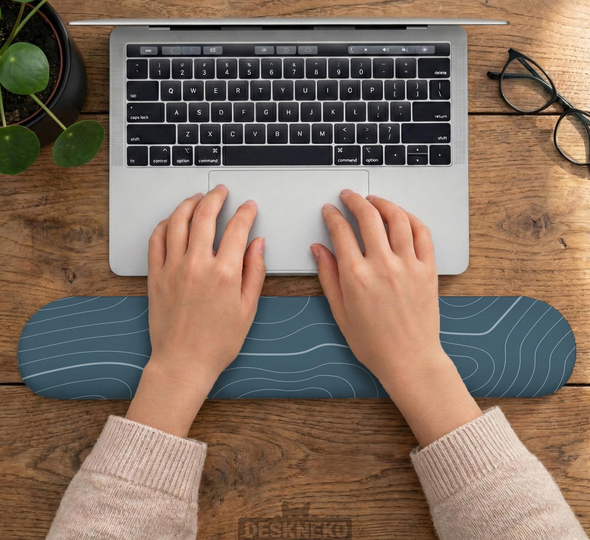 Muted blue desk mat with thin topographic line art pattern shown with matching mousepad and keyboard wrist rest options.