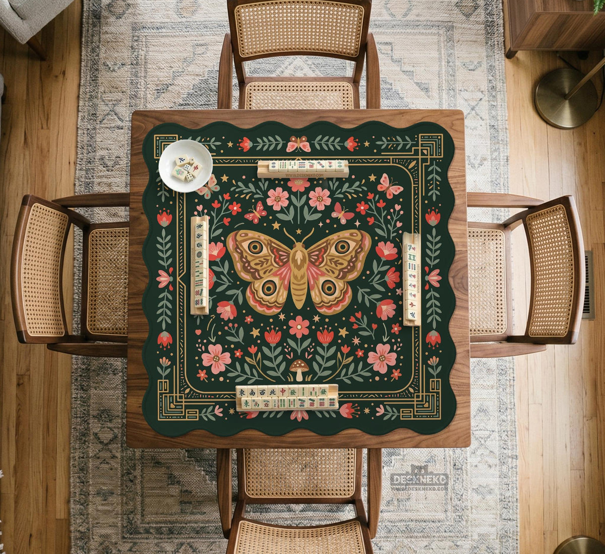 Dark green square mahjong mat with floral branches, small red blossoms, gold line details, and a large moth in the center.
