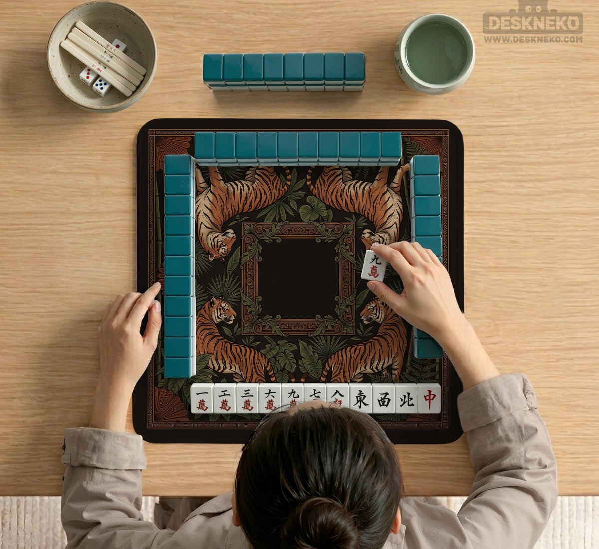 Black square mahjong mat with mirrored tiger faces, bamboo, dark tropical leaves, ornate border details, and orange accents.