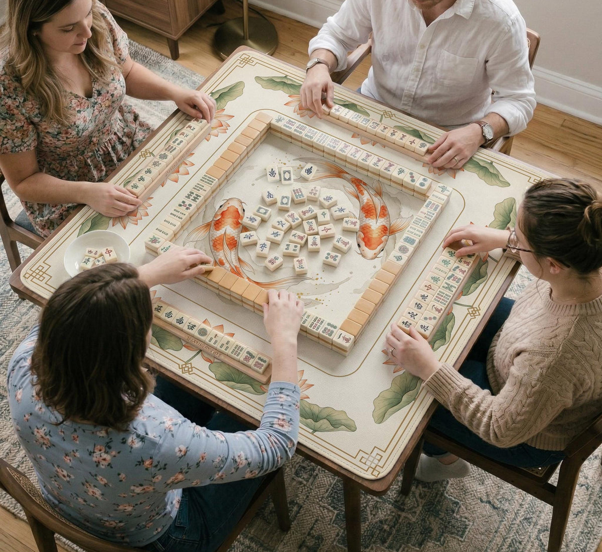 Ivory square mahjong mat with watercolor koi fish, lotus flowers, peach blossoms, sage leaves, and a thin gold border.