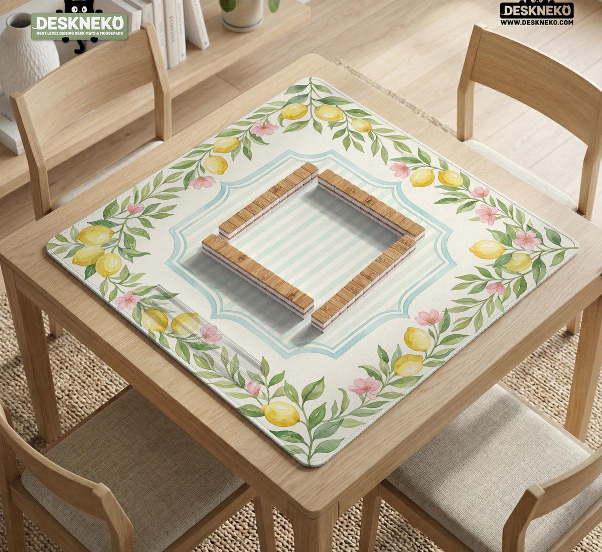 Square yellow mahjong mat with a citrus garden border, green vines, pink blossoms, aqua accents, and a plain center play area.
