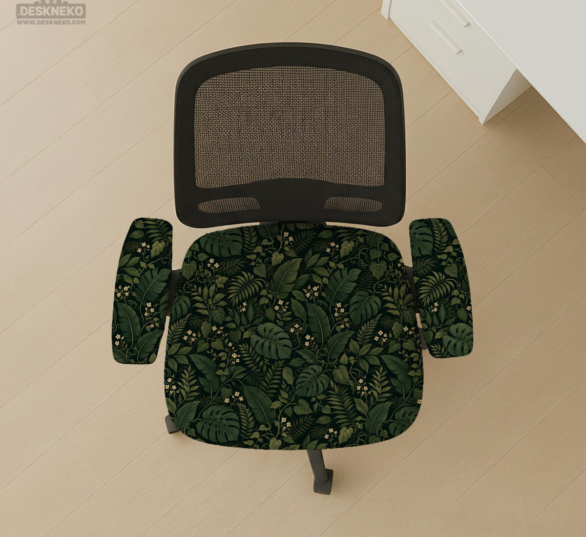 Forest green chair cover with a tropical leaf pattern featuring monstera leaves and small cream flowers.