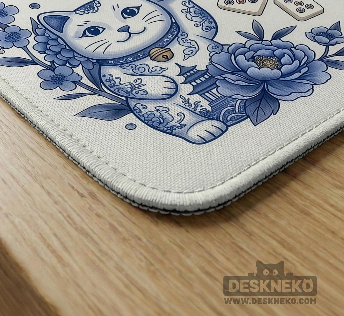 Blue and white square mahjong mat with lucky cat artwork, floral chinoiserie pattern, tile icons, and a rule guide layout.