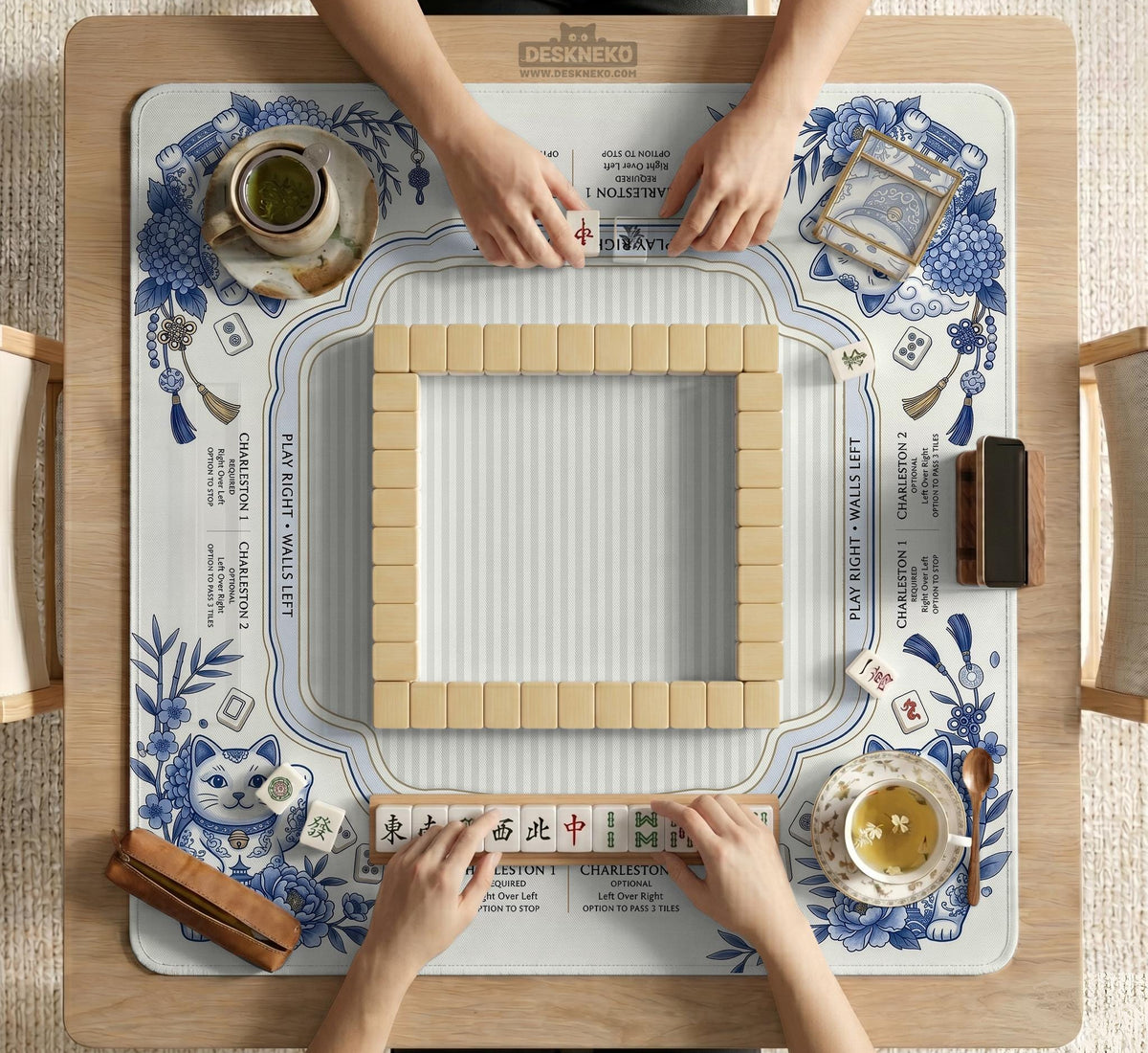 Blue and white square mahjong mat with lucky cat artwork, floral chinoiserie pattern, tile icons, and a rule guide layout.