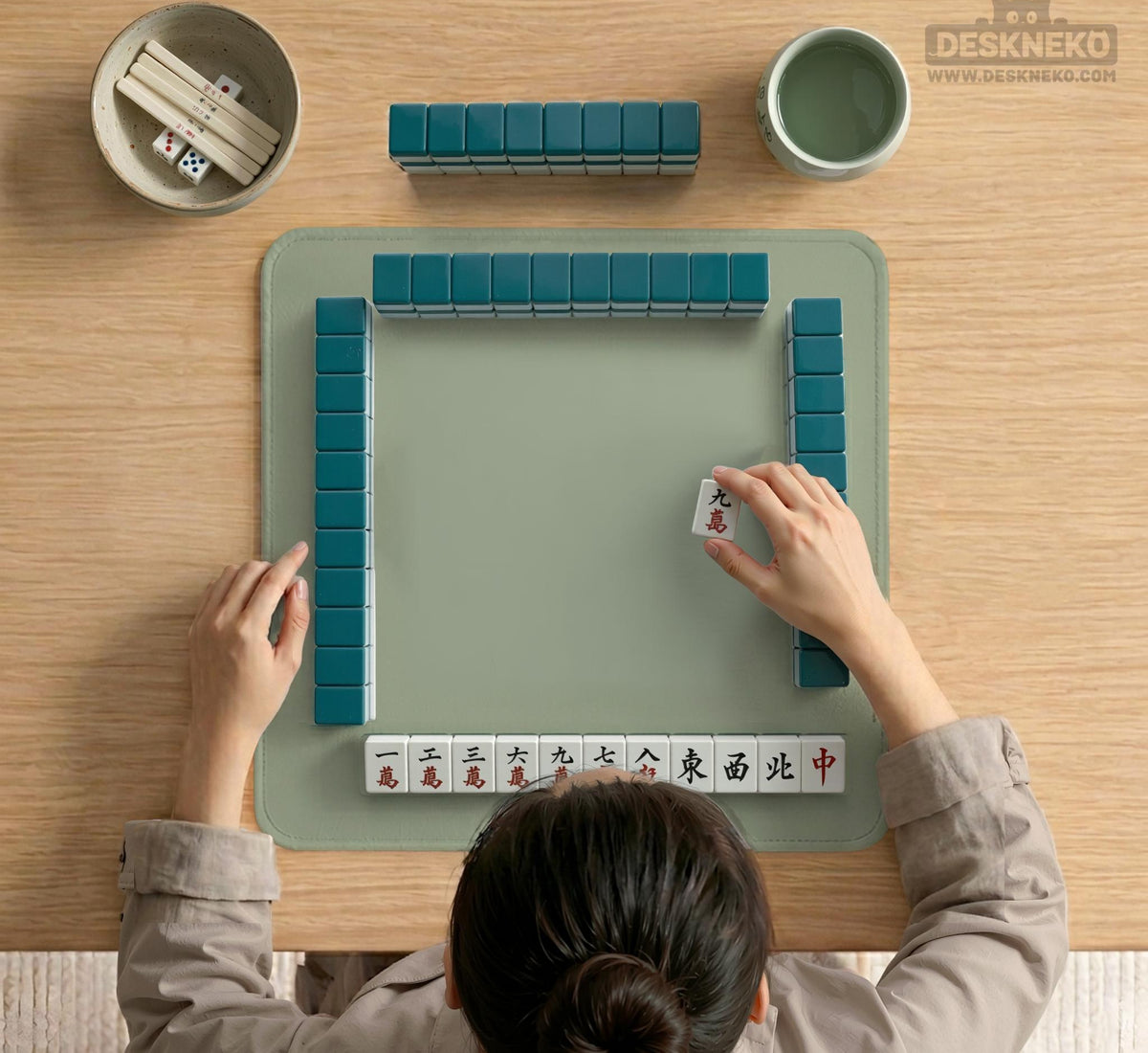 A plain light sage green square mahjong mat with a smooth solid-color surface.