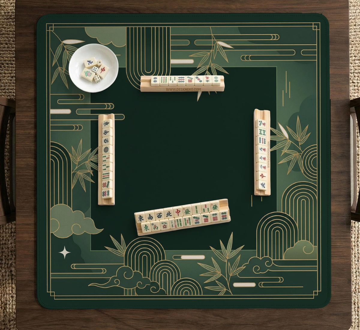 Square emerald green mahjong mat with bamboo line art, gold geometric cloud shapes, and a plain center playing area.