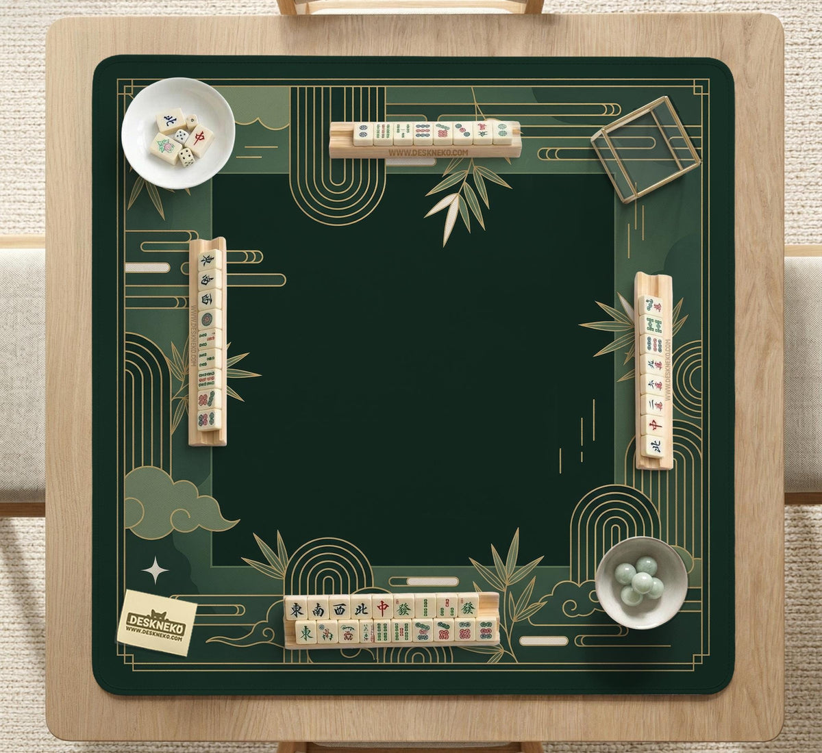 Square emerald green mahjong mat with bamboo line art, gold geometric cloud shapes, and a plain center playing area.