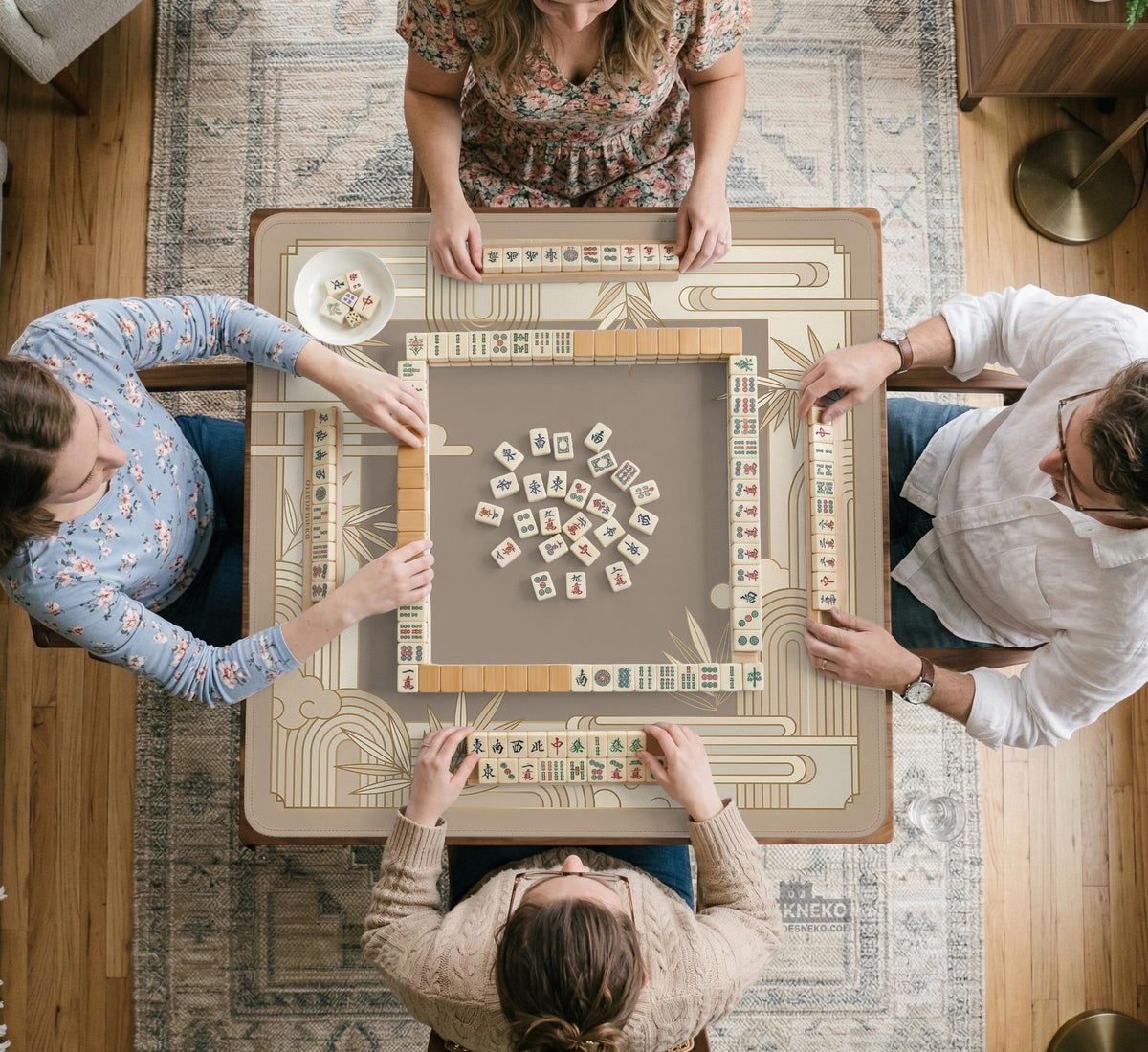 Beige and gold square mahjong mat with a bamboo pattern and geometric border.
