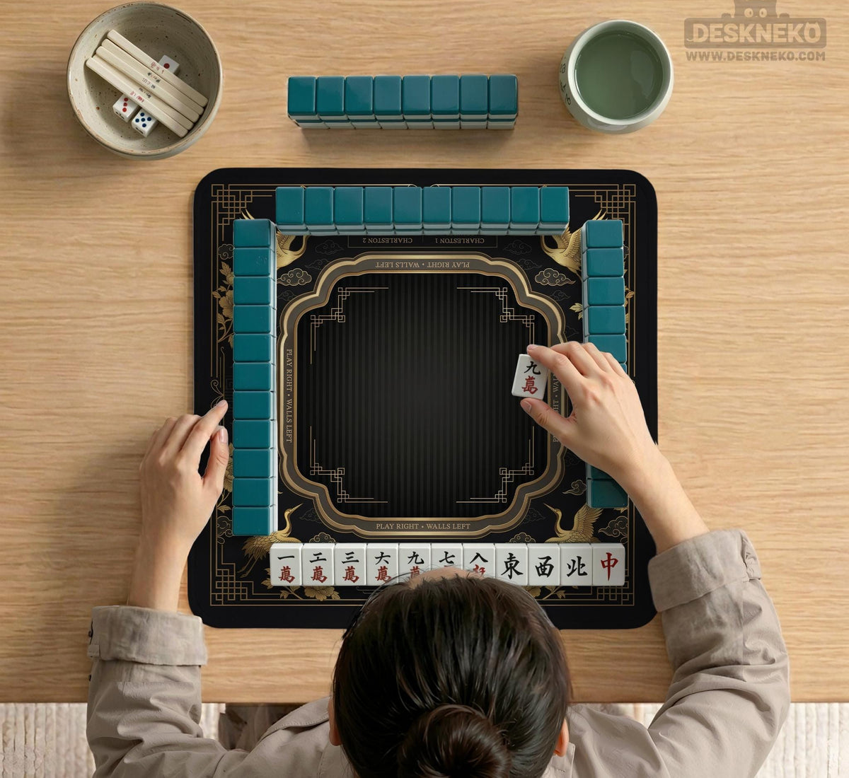Black and gold square mahjong mat with an art deco crane and floral border, rule reminders around the edges, and a blank center area.
