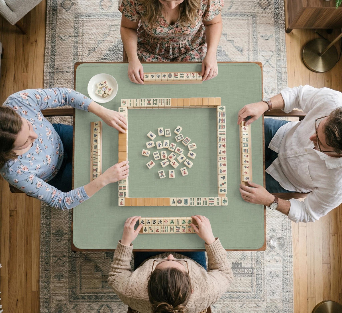 A square sage green mahjong mat with scalloped edges on a plain background.