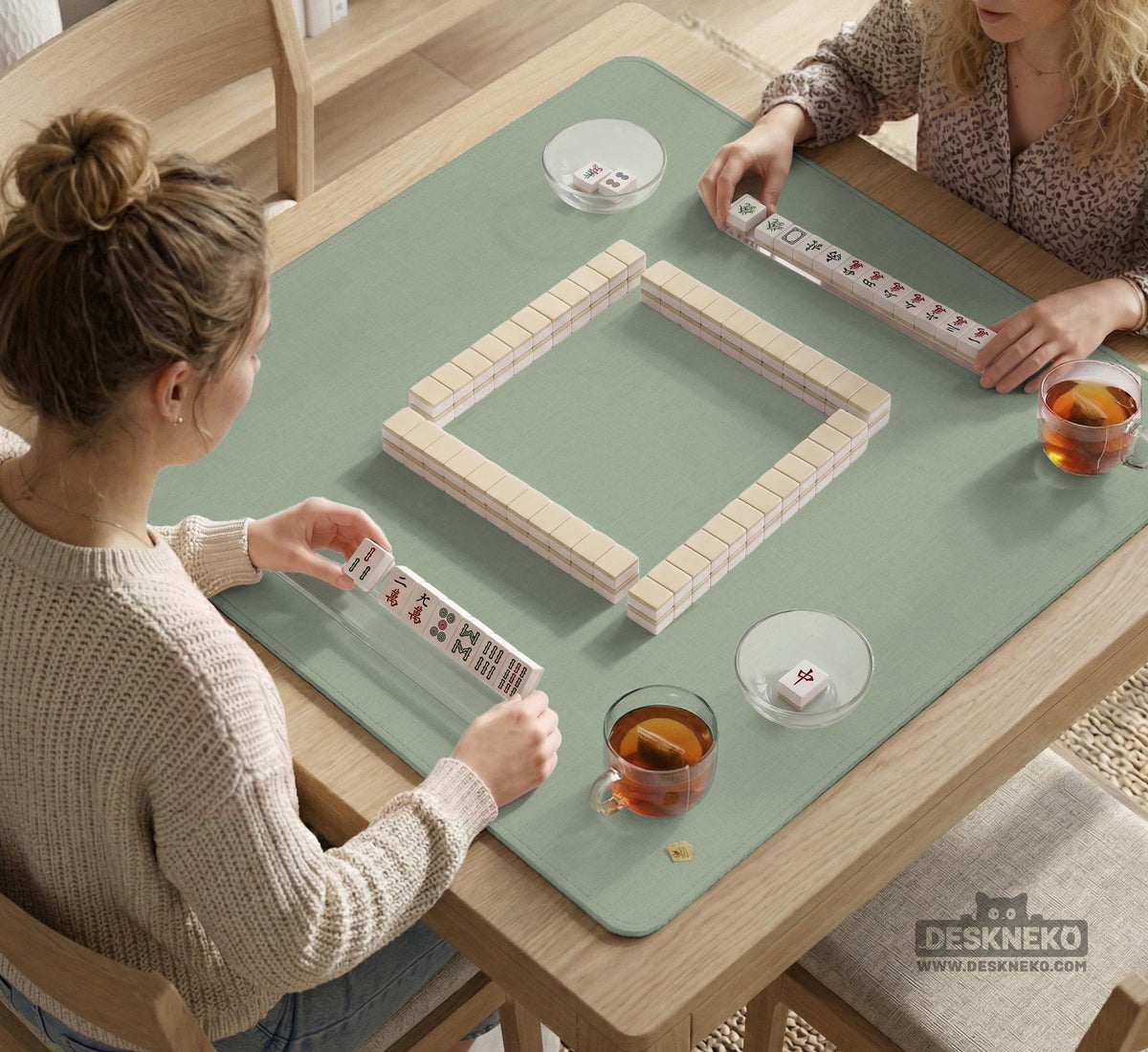 A square sage green mahjong mat with scalloped edges on a plain background.