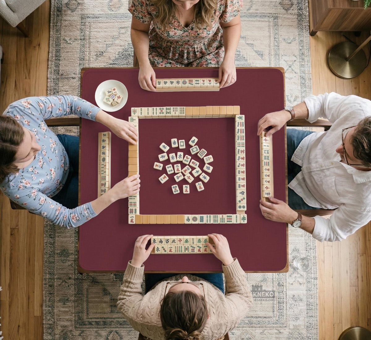Plain burgundy square mahjong mat with scalloped edges on a white background.