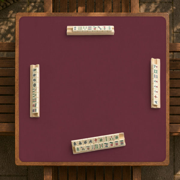 Plain burgundy square mahjong mat with scalloped edges on a white background.