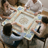 A square mahjong mat with blue hydrangea flowers, green vines, a cream background, a striped center, and printed rules around the border.