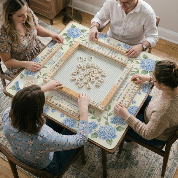 A square mahjong mat with blue hydrangea flowers, green vines, a cream background, a striped center, and printed rules around the border.