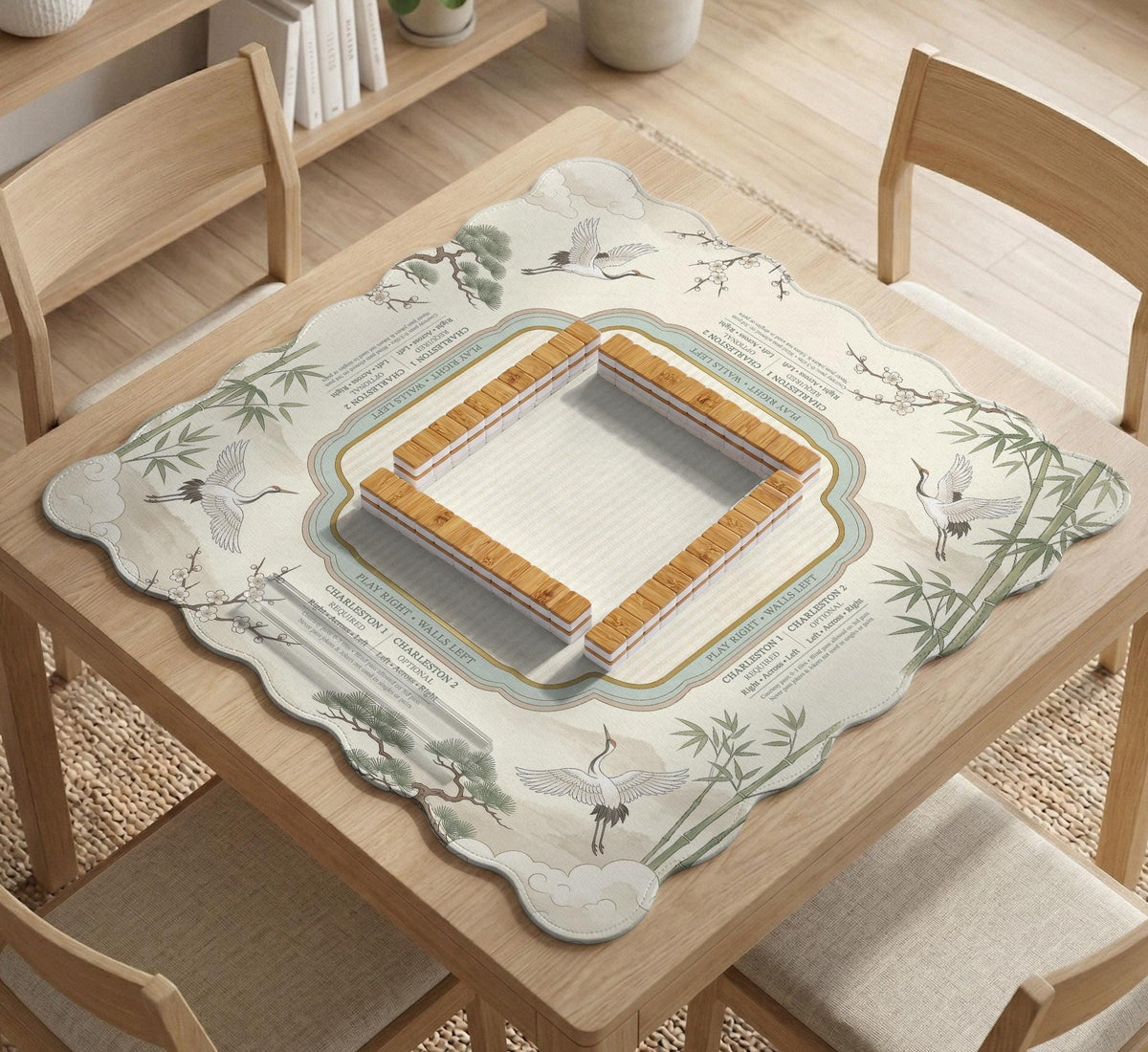 Sage green scalloped mahjong mat with bamboo, crane, and blossom illustration and printed rules around the border.