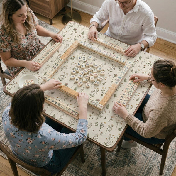Cream mahjong mat with a floral pattern of small wildflowers and sage leaves, shown with a scalloped edge on a light neutral background.