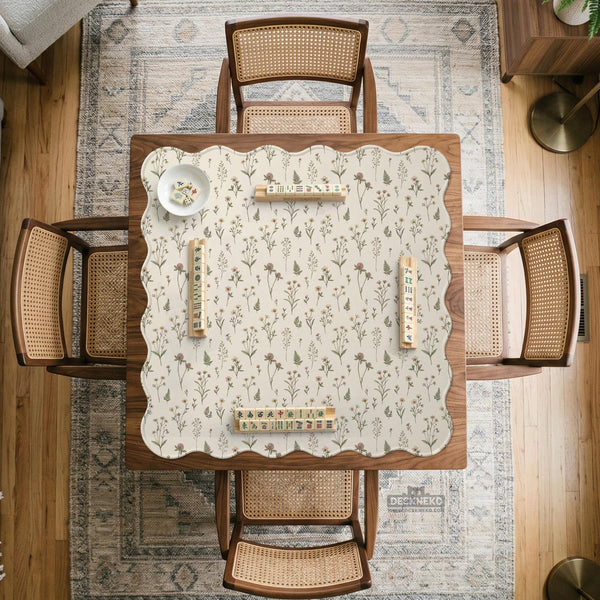 Cream mahjong mat with a floral pattern of small wildflowers and sage leaves, shown with a scalloped edge on a light neutral background.