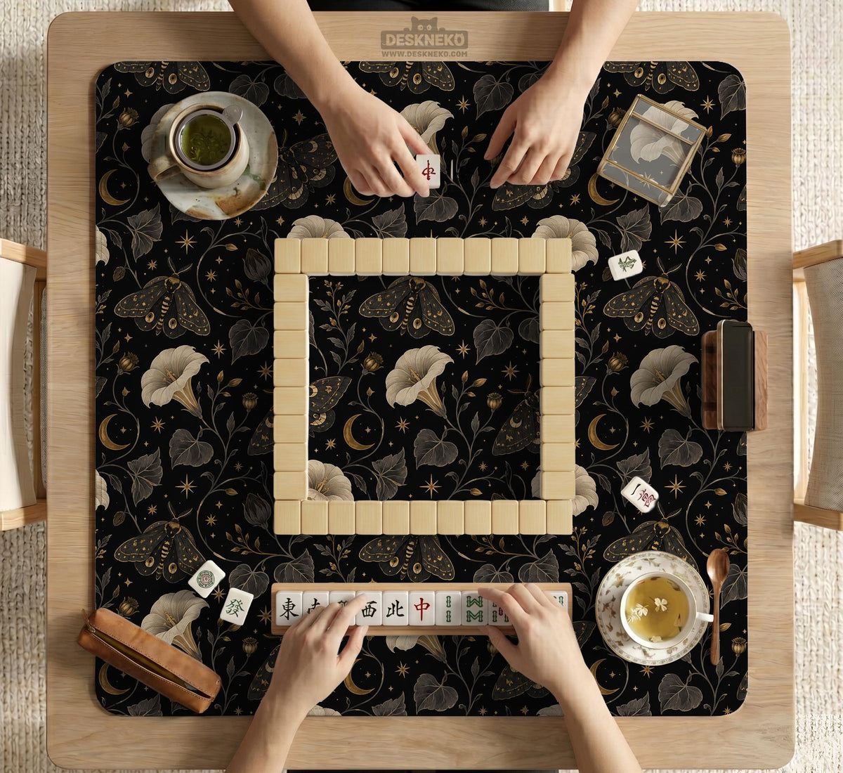 Black square mahjong mat with moths, moonflowers, crescent moons, and scattered stars in a celestial floral pattern.