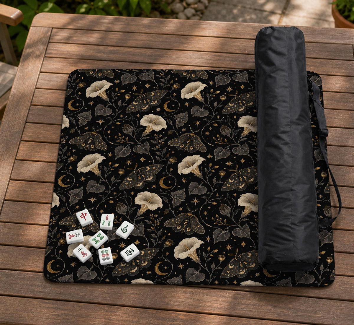 Black square mahjong mat with moths, moonflowers, crescent moons, and scattered stars in a celestial floral pattern.