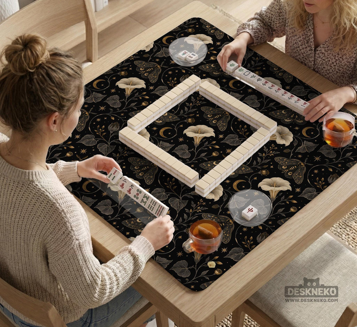 Black square mahjong mat with moths, moonflowers, crescent moons, and scattered stars in a celestial floral pattern.