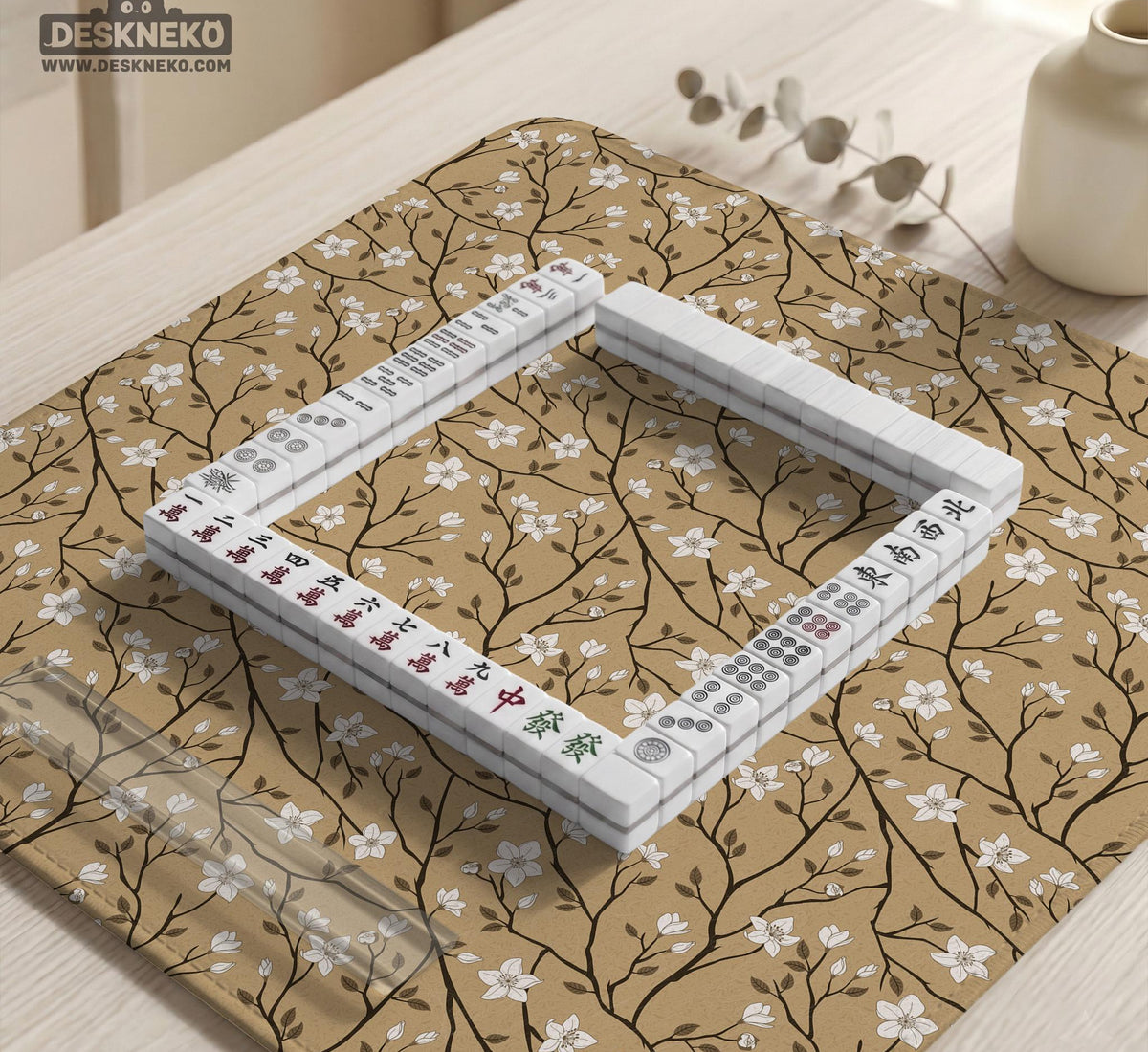 Beige mahjong mat with a white blossom branch floral pattern on a neutral background.
