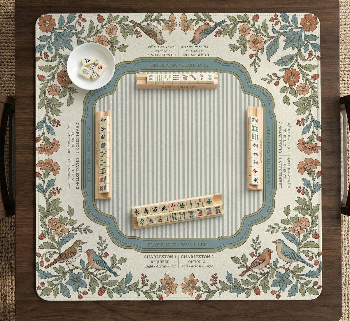 Square mahjong mat with a cream background, blue birds, sage leaves, terracotta flowers, and a decorative botanical border with printed rules text.