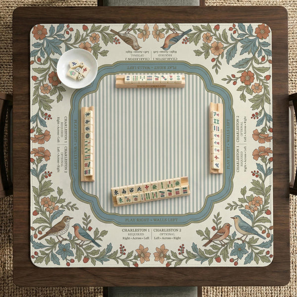 Square mahjong mat with a cream background, blue birds, sage leaves, terracotta flowers, and a decorative botanical border with printed rules text.