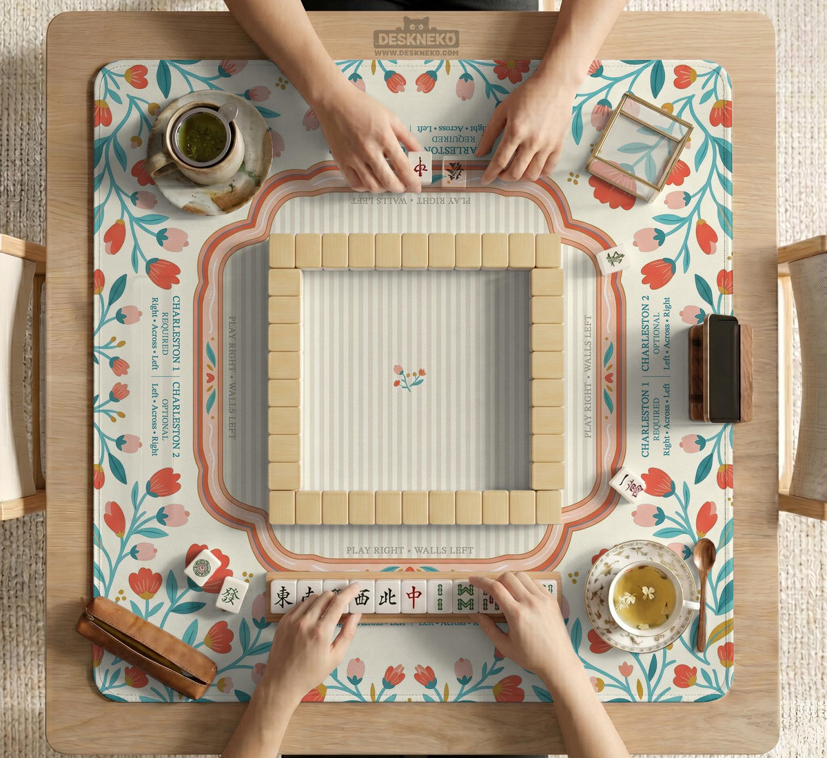Cream mahjong mat with a coral and teal floral border, rule layout text, Charleston guide notes, and a blank center area for tile play.