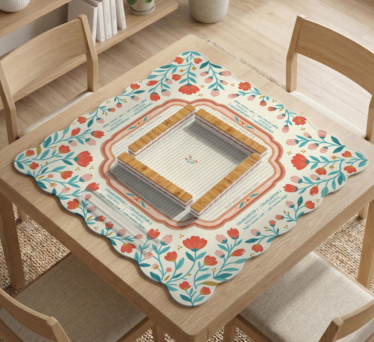 Cream mahjong mat with a coral and teal floral border, rule layout text, Charleston guide notes, and a blank center area for tile play.