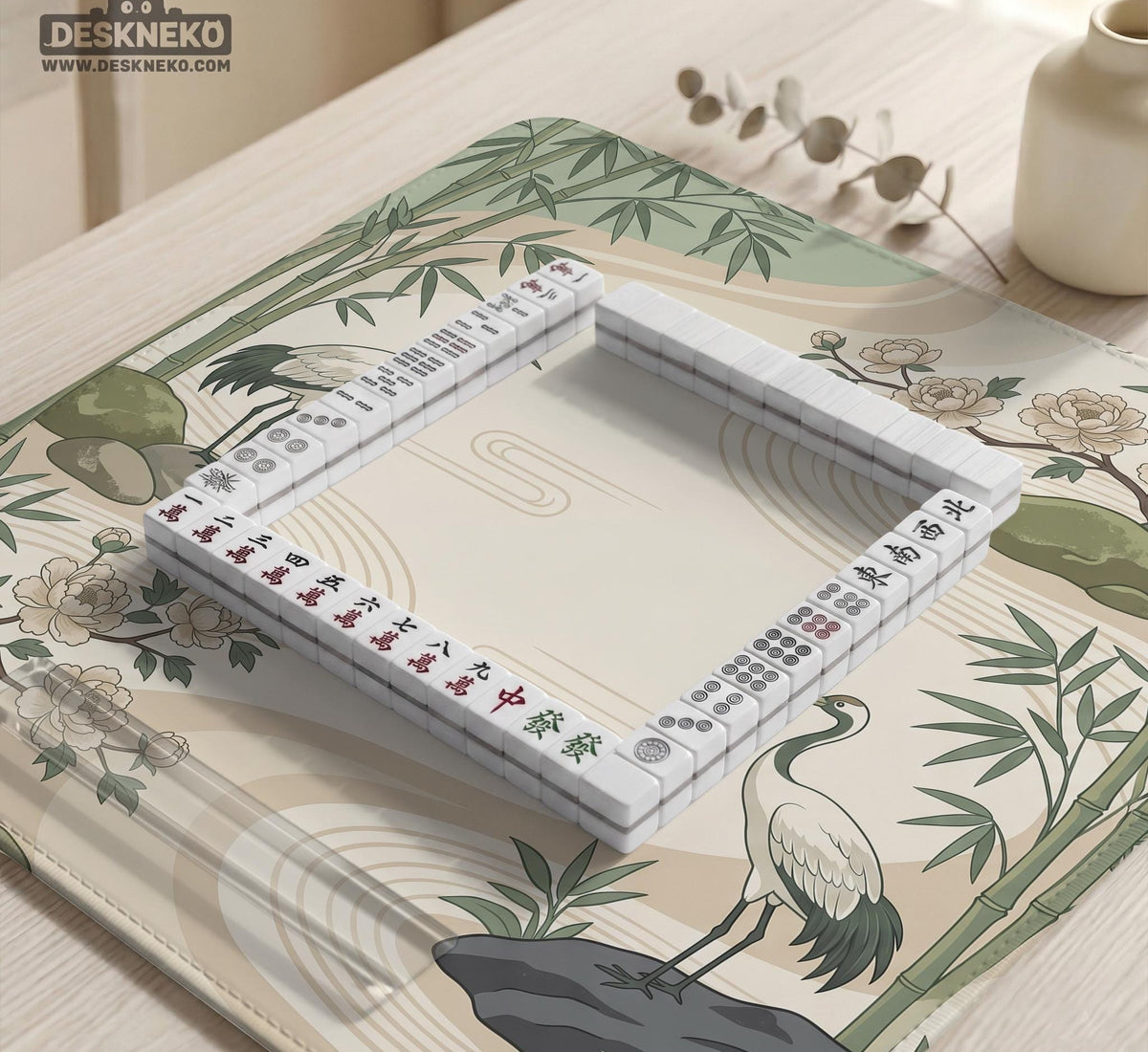 Square mahjong mat with a cream background, sage green cranes, bamboo leaves, peony branches, stones, and thin linework.