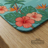 A square mahjong mat with flamingos, hibiscus flowers, palm leaves, and aqua water accents on a coral background with a scalloped edge.