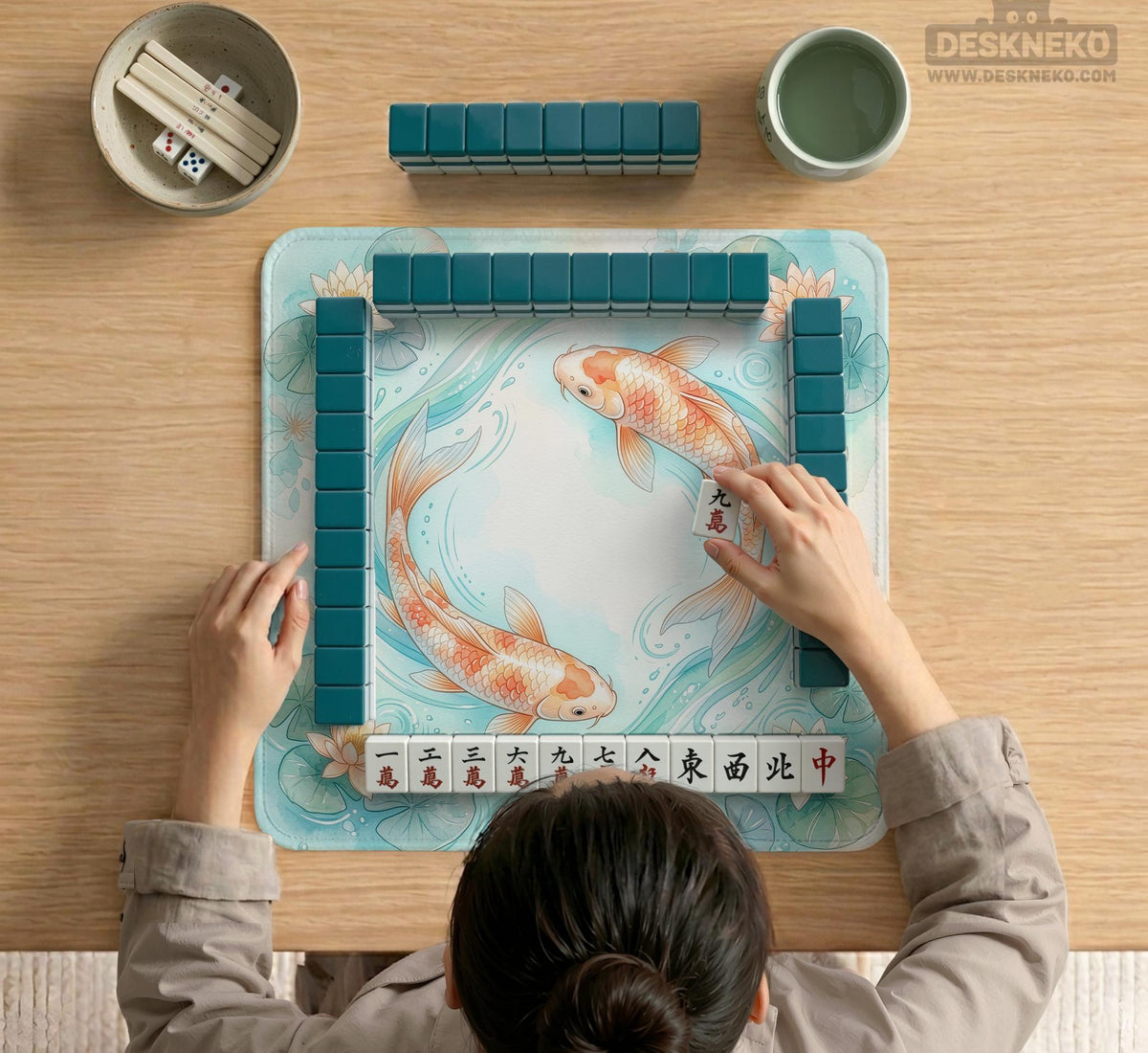 A soft blue mahjong mat with koi fish, floating lily pads, pale floral details, and a watercolor-style pond design.