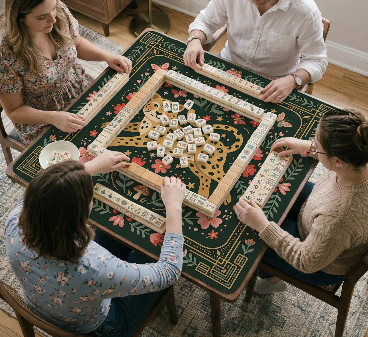 Dark green square mahjong mat with a golden spotted leopard in the center, surrounded by flowers, leafy stems, butterflies, and small star accents.