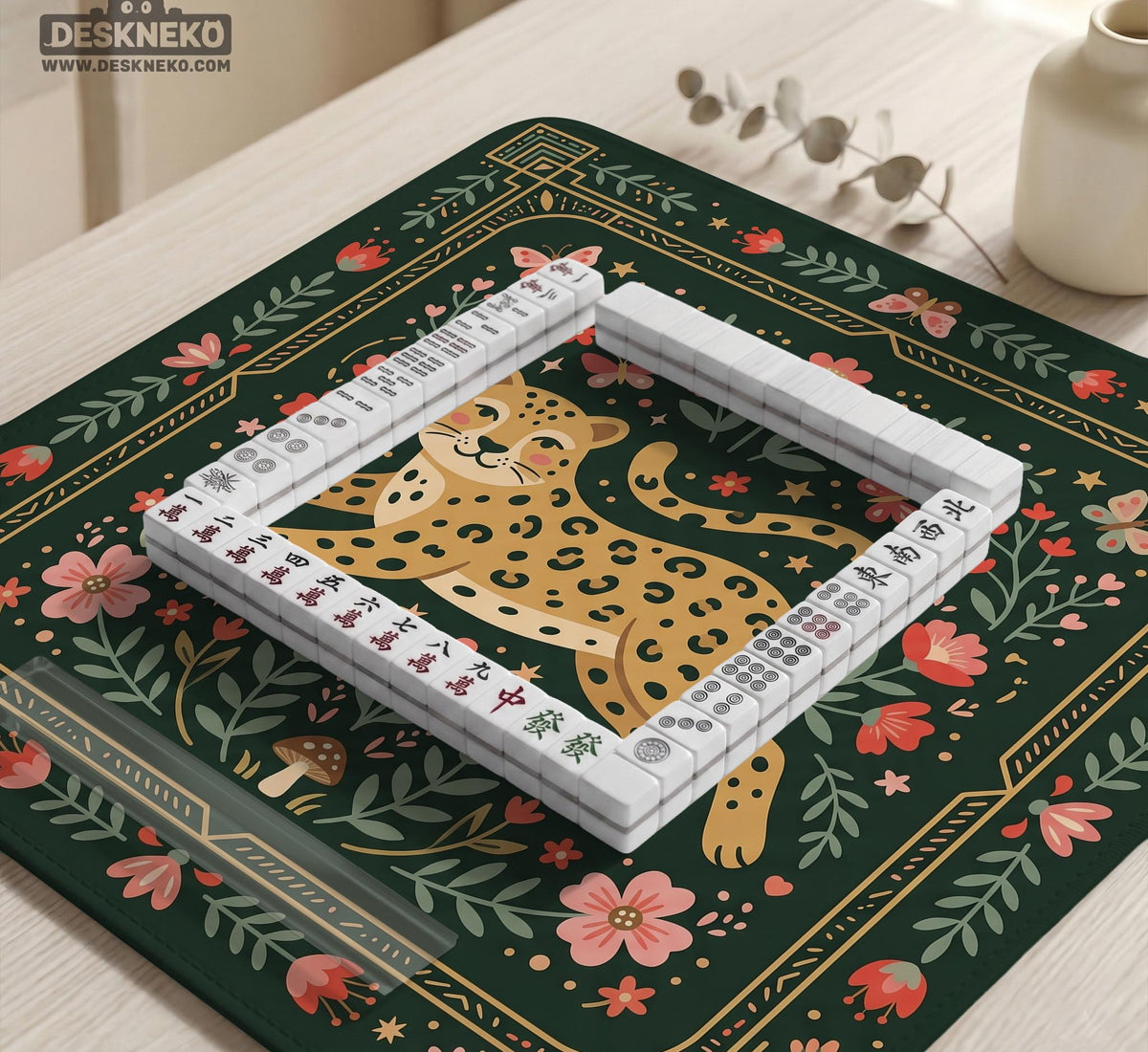 Dark green square mahjong mat with a golden spotted leopard in the center, surrounded by flowers, leafy stems, butterflies, and small star accents.