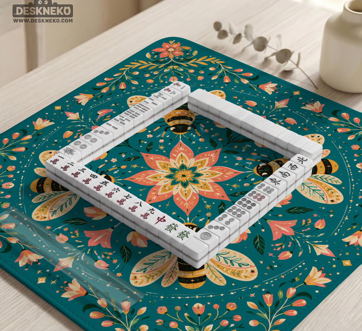 Green mahjong mat with a botanical bee and floral mandala design in teal, coral, cream, and gold.