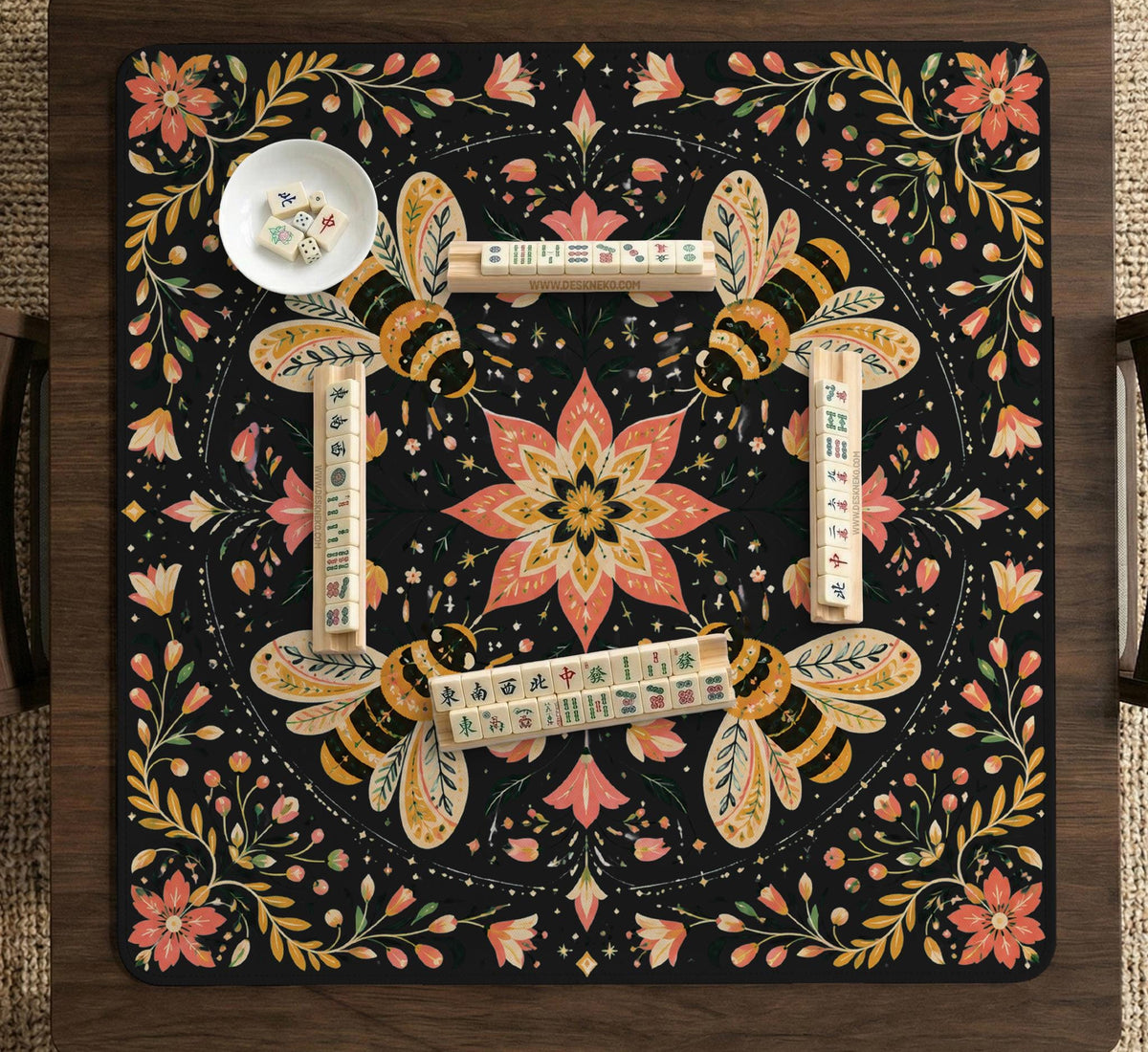 Black mahjong mat with a symmetrical botanical design, coral flowers, golden leaves, and small bees.