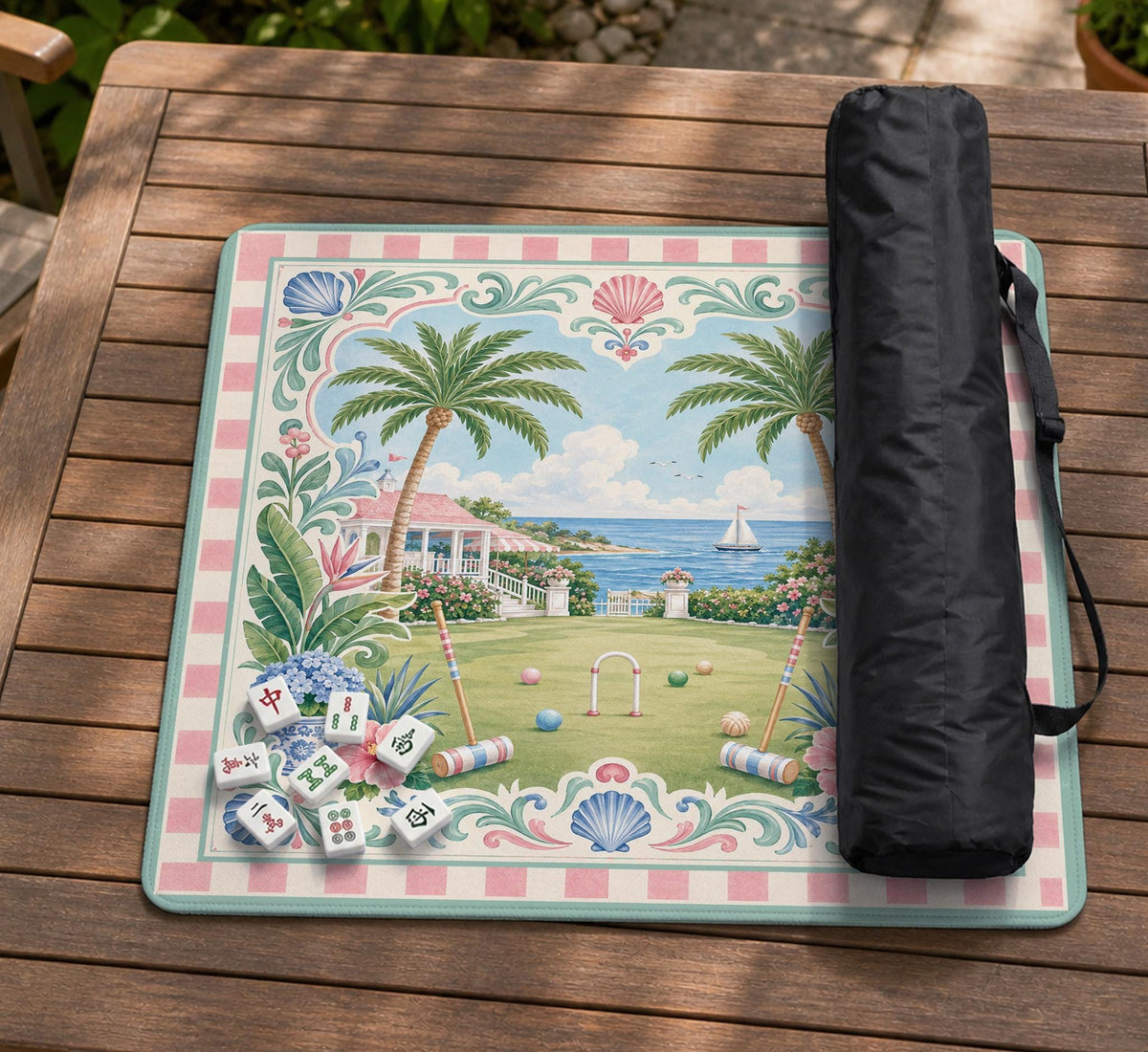 Pastel mahjong mat with a pink gingham border, seashells, hydrangea pots, palm trees, croquet details, and a coastal garden scene.