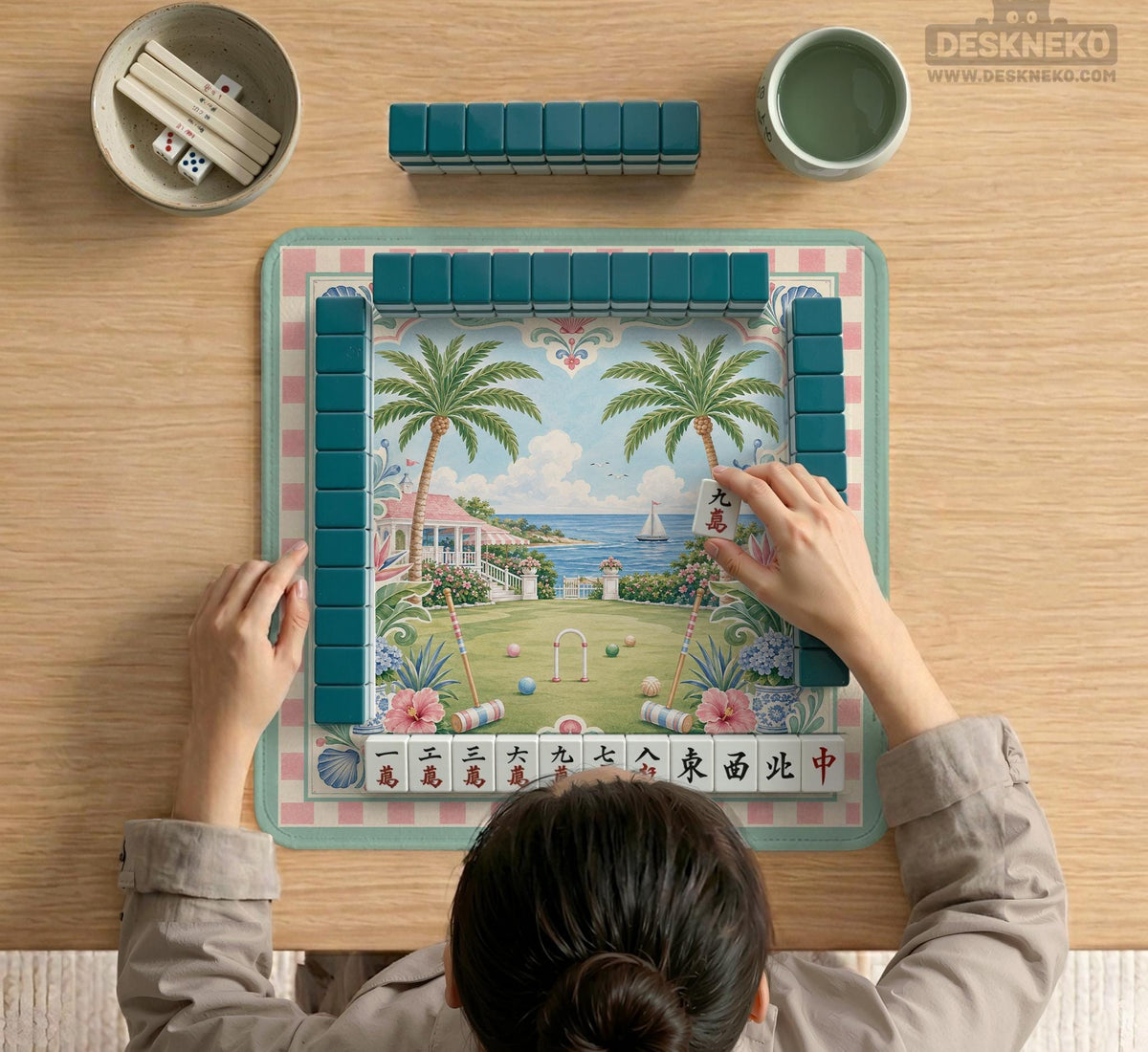Pastel mahjong mat with a pink gingham border, seashells, hydrangea pots, palm trees, croquet details, and a coastal garden scene.