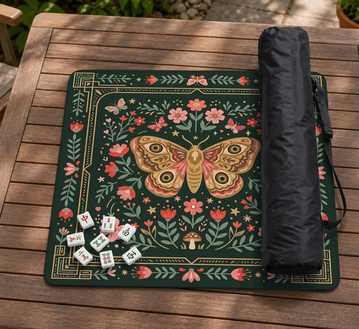Dark green square mahjong mat with floral branches, small red blossoms, gold line details, and a large moth in the center.