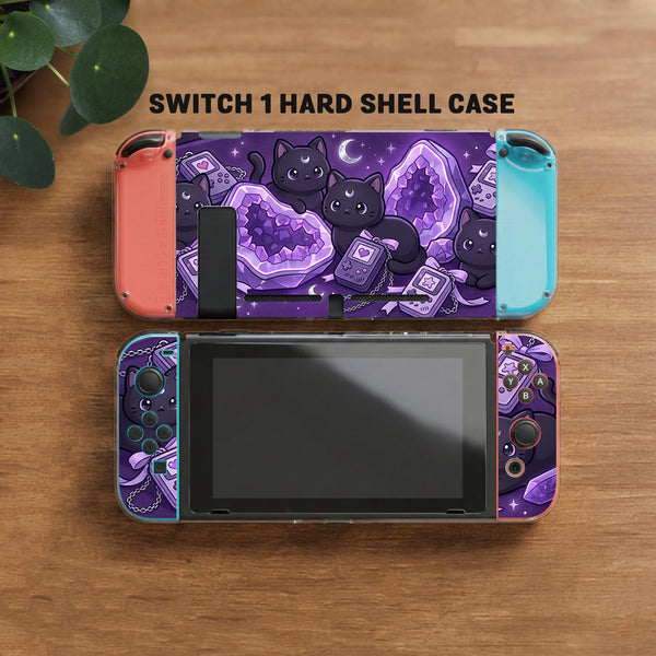 Purple carrying case with black cat faces, moon shapes, stars, and crystal geode style artwork for Nintendo Switch.