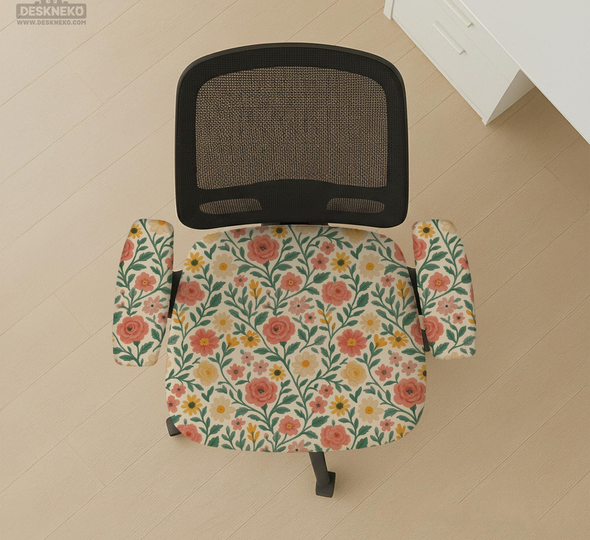 Cream desk chair cover with a vintage floral print featuring coral roses, mustard daisies, and green vines on a chair.