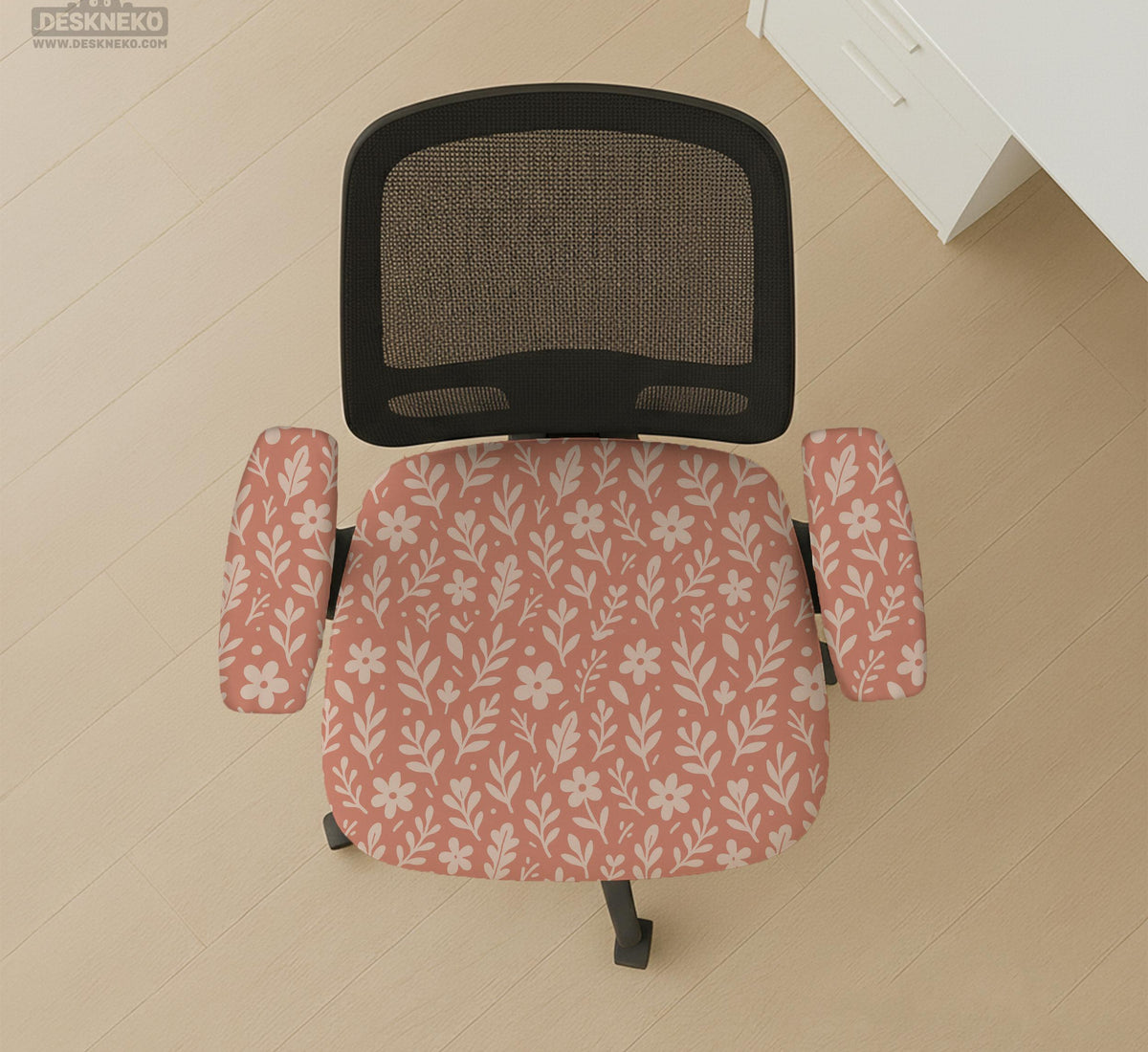 Pink chair cover with a botanical floral print shown on an office chair, with matching armrest covers and multiple cover style options.