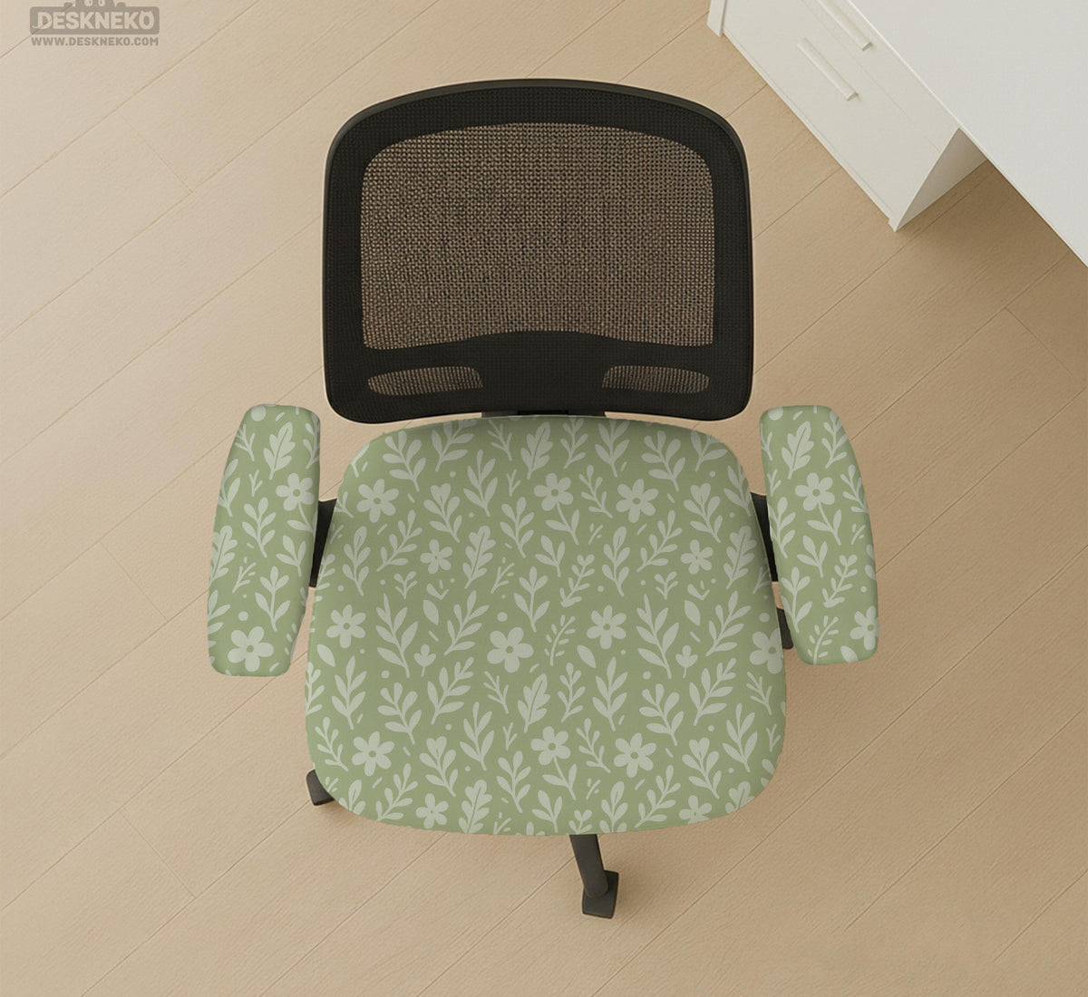 Sage green desk chair cover with a small floral and leaf print shown on an office chair.