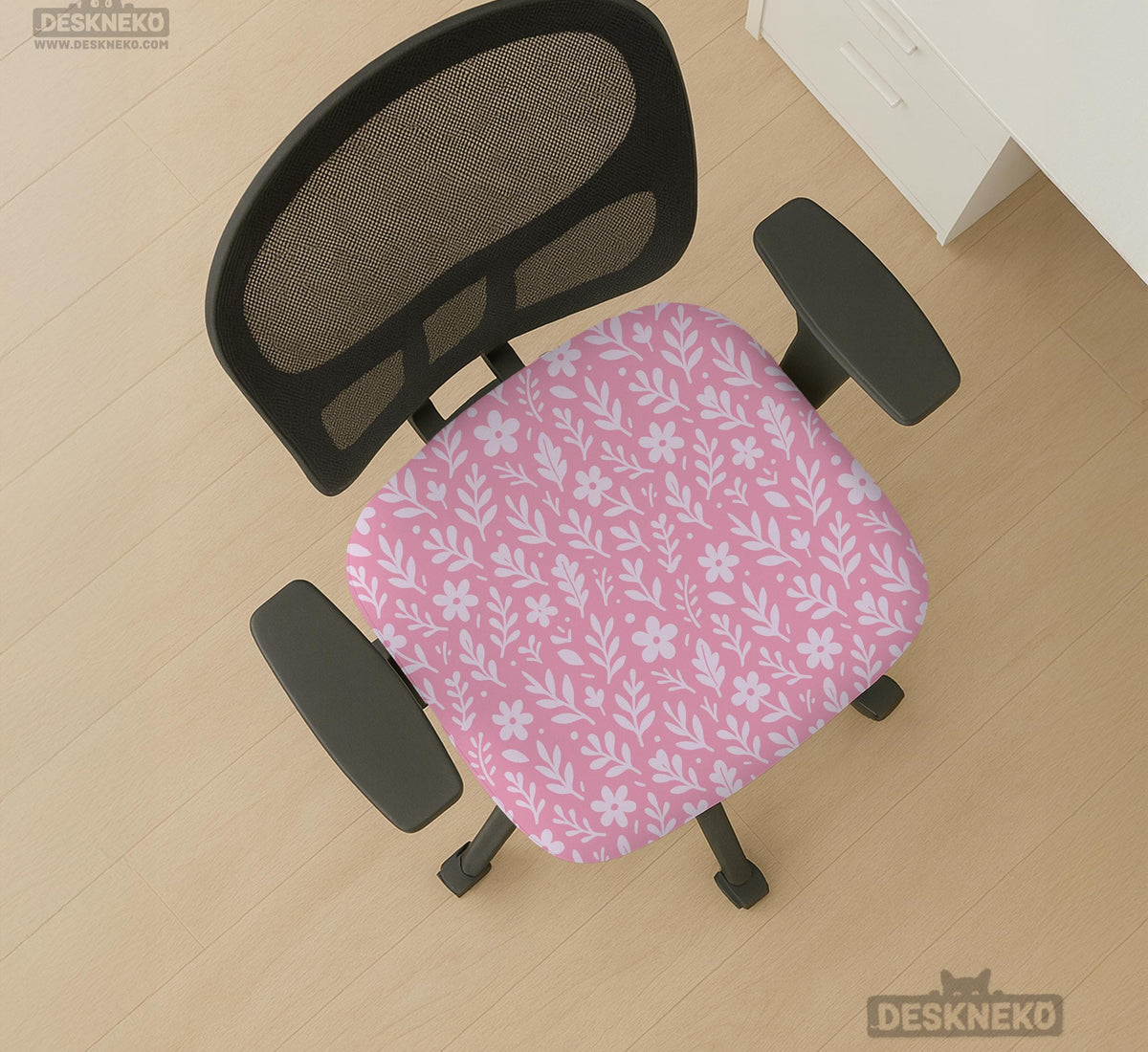 Blush pink chair cover with a small botanical floral pattern shown on an office chair.
